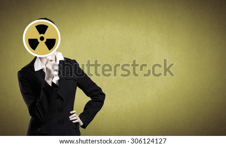 Unrecognizable businesswoman hiding her face behind radioactivity sign