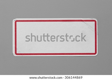 Stickers Label Close Up on Grey Background with Real Shadow. Top View of Adhesive Paper Tag with a Red Border. Copy Space for Text or Image