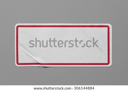 Stickers Label Close Up on Grey Background with Real Shadow. Top View of Adhesive Paper Tag with a Red Border. Copy Space for Text or Image