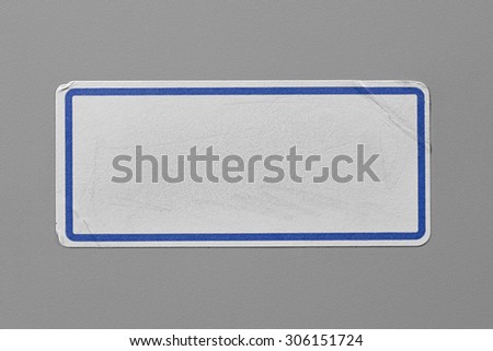 Label Adhesive with Dirt and Scratches Close Up on Grey Background with Real Shadow. Top View of Adhesive Paper Tag with Blue Border. Stickers with Copy Space for Text or Image