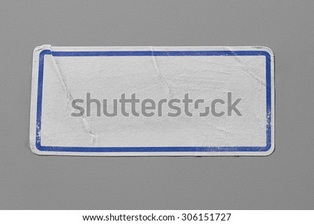 Label Adhesive with Dirt and Scratches Close Up on Grey Background with Real Shadow. Top View of Adhesive Paper Tag with Blue Border. Stickers with Copy Space for Text or Image