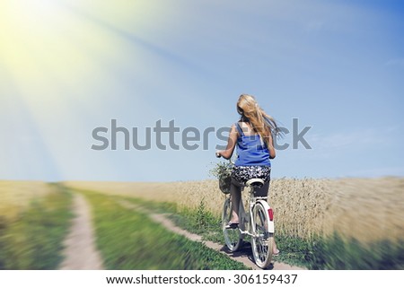 Picture of romantic pretty female travel with cycle on the wheat field outdoors copy space background
