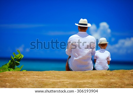 rear view of father and son sitting together on sky horizon Royalty-Free Stock Photo #306193904