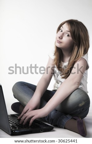 casual teenage girl on a laptop on a white background working on the floor