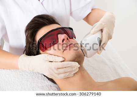 Close-up Of Beautician Giving Laser Epilation Treatment To Young Man Face Royalty-Free Stock Photo #306279140