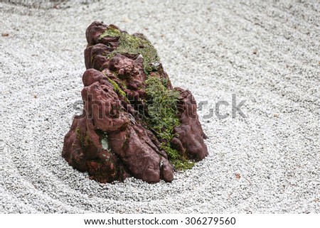 Isolated Stone in a Japanese Zen Garden with White Sand and Moss