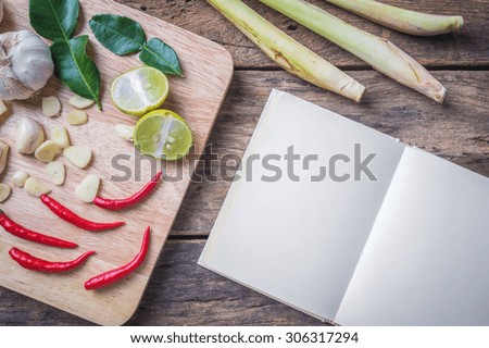 Wooden chopping board and ingredients on wood background