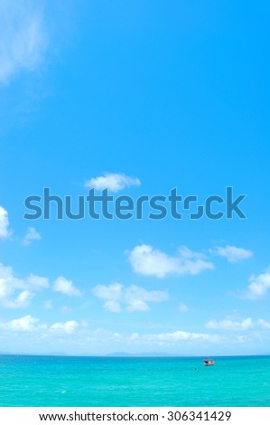 Turquoise sea beach with boat and blue sky