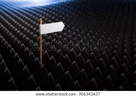 blank white directional sign on bumpy black background horizontal view