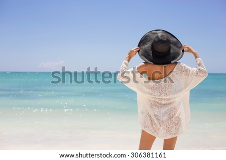 Woman in summer hat on the beach