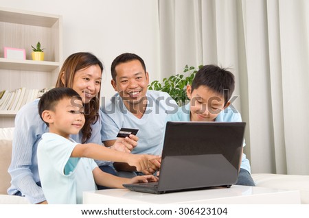 Asian family using laptop to perform online shopping Royalty-Free Stock Photo #306423104
