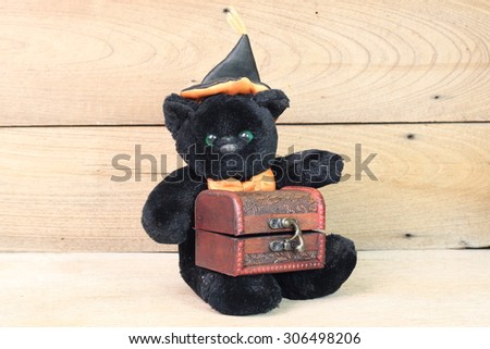 Black Bear holding onto a wooden treasure chest.