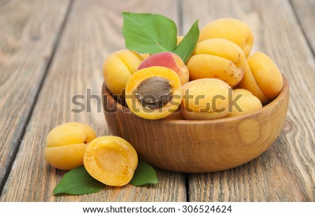 Ripe apricots in the plate on a wooden background