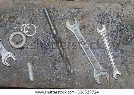 universal key , nut, metal shavings , drill on the workplace in the garage