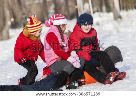 Children in winter park having fun and playing snowballs