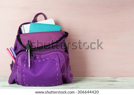 School backpack on wooden background Royalty-Free Stock Photo #306644420