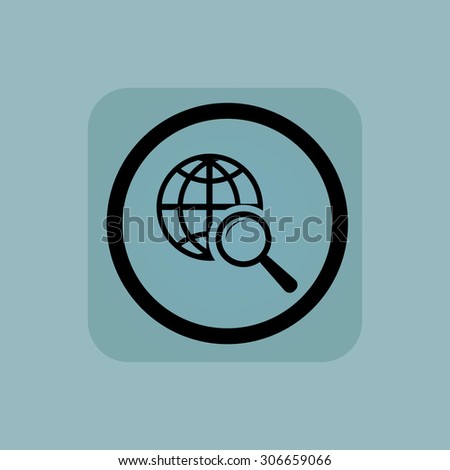 Globe under loupe in circle, in square, on pale blue background