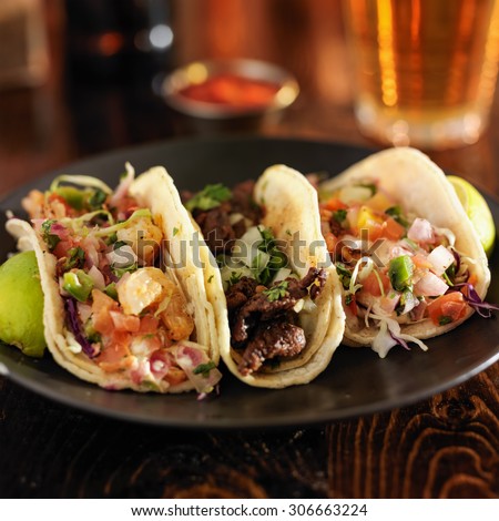 three different mexican street tacos with shrimp, steak, and fish