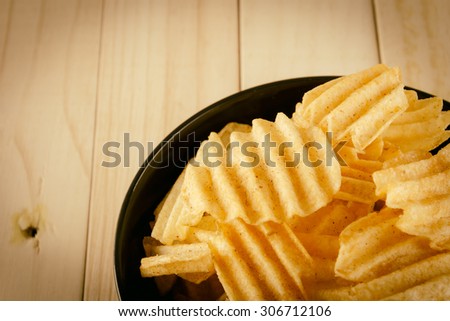 potato chips on wood - soft focus with vintage film filter
