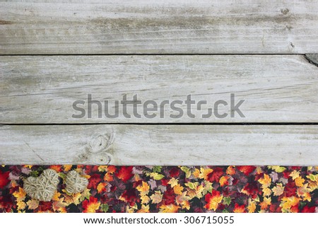 Blank rustic wood sign with rope hearts and fall decor border of colorful leaves