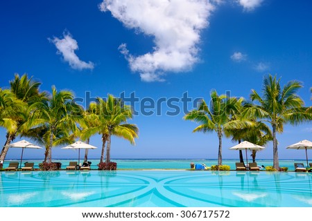 Tropical beach resort with  lounge chairs and umbrellas, Mauritius Royalty-Free Stock Photo #306717572