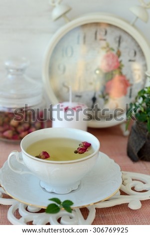 Cup of healthy green tea with dried roses