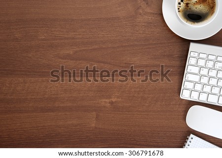 View from above with copy space, office table with notepad, keyboard and coffee cup. 