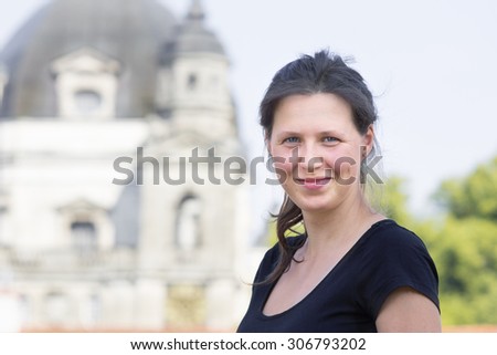 Young smiling woman with blurry church in a background