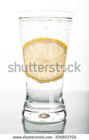 Photo of glass of water with lemon slice on white background