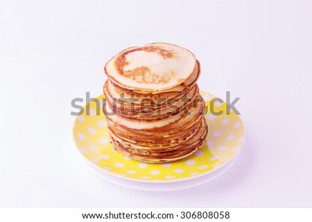 Stack of pancakes on a plate isolated on white background. Selective focus.