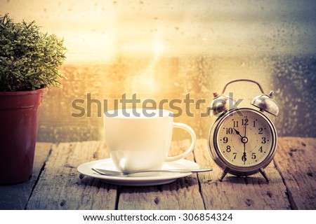 Steaming coffee cup on a rainy day window background,good time of coffee Royalty-Free Stock Photo #306854324