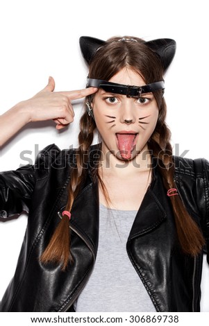 Funny girl represents as small cat.  Woman  with bright makeup hairstyle of girl with leather cat ears and braids having fun. On white background not isolated