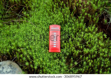 Red phone booth in the green moss
