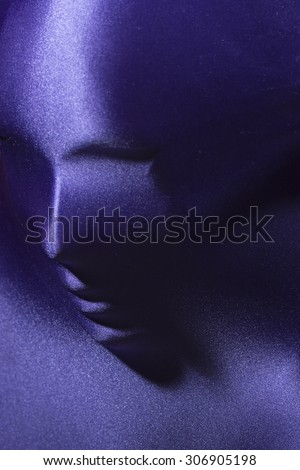 Mysterious closeup portrait background of female human face under beautiful pearl purple supplex stretch fabric copyspace, vertical picture