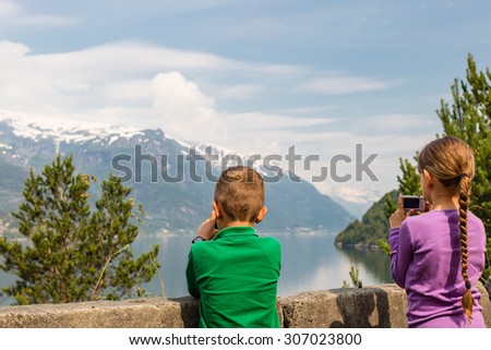 Young kids in Norway taking pictures of the surrounding scenery with their compact digital cameras.