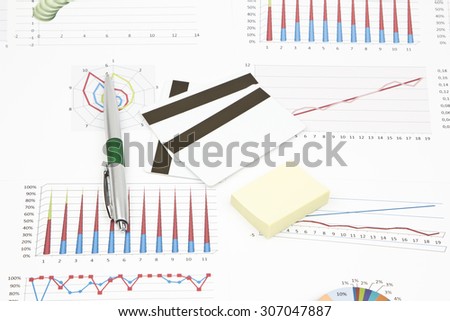 Business still-life of a pen, credit card, charts, graphs, stickers
