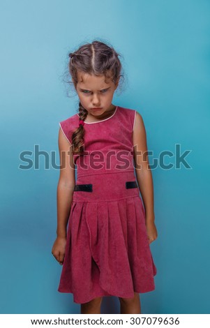 Girl European appearance decade  angry frowns blue background