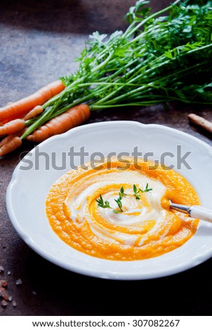 Carrot Soup on dark wooden background