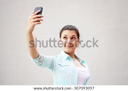Girl taken pictures of her self on gray background 