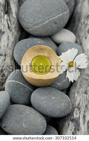 White flower  with handmade yellow candle on old wood