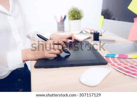 Close up view of an artist drawing something on graphic tablet at the office