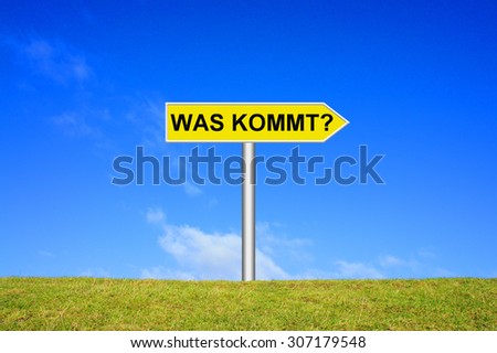 Street Sign showing what is coming in german language in front of blue sky on green grass
