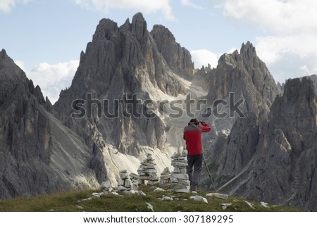 Man hiking. Photographer in Dolomites Mountains