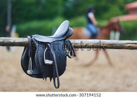 A leather saddles horse in a stable at the summer time