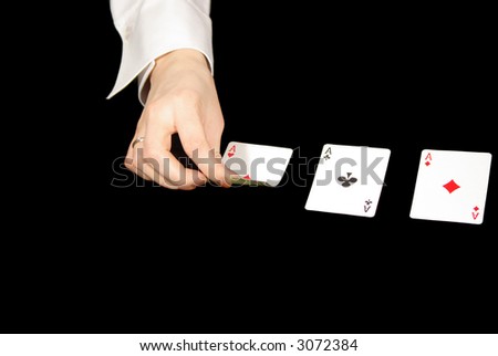 third ace is coming - playing cards and human hand isolated on black