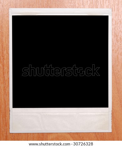  instant photo frame isolated on a wooden background