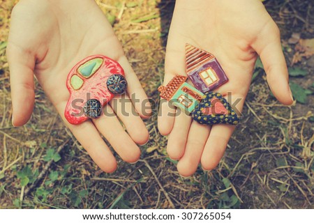 toy car, houses and heart in hands