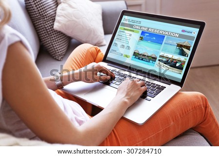 Woman using laptop to book hotel online Royalty-Free Stock Photo #307284710