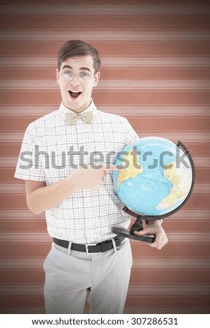 Geeky hipster holding a globe smiling at camera against background