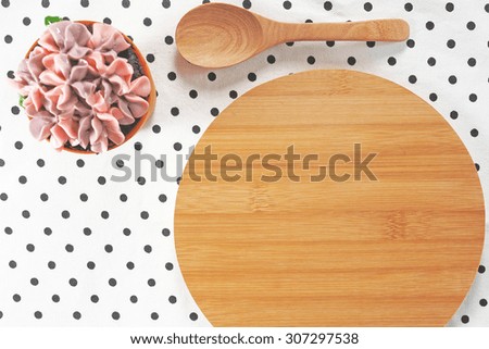 Sweet cupcake and wooden board on vintage tablecloth background. Toned image.